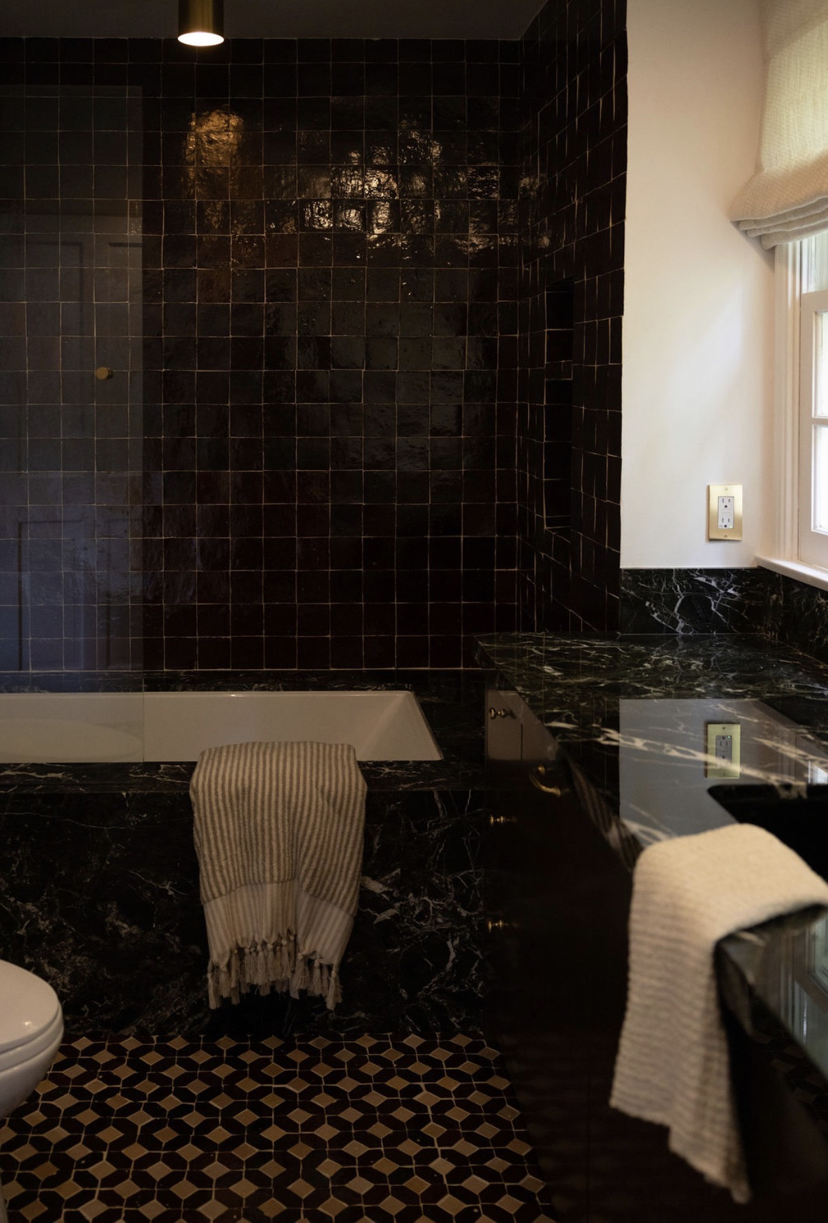 Dark-tiled bathroom with clawfoot tub